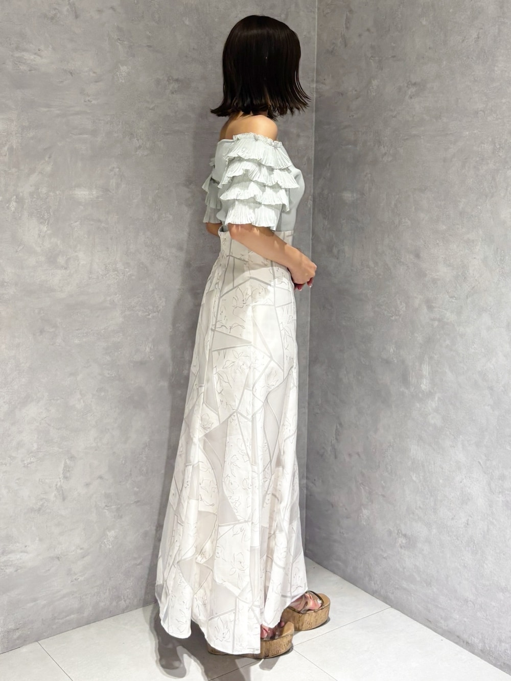 ホワイト系のスカート、グリーン系のニット/セーター、ブラウン系のサンダルを着用したレディースの夏コーディネートの5枚目の写真