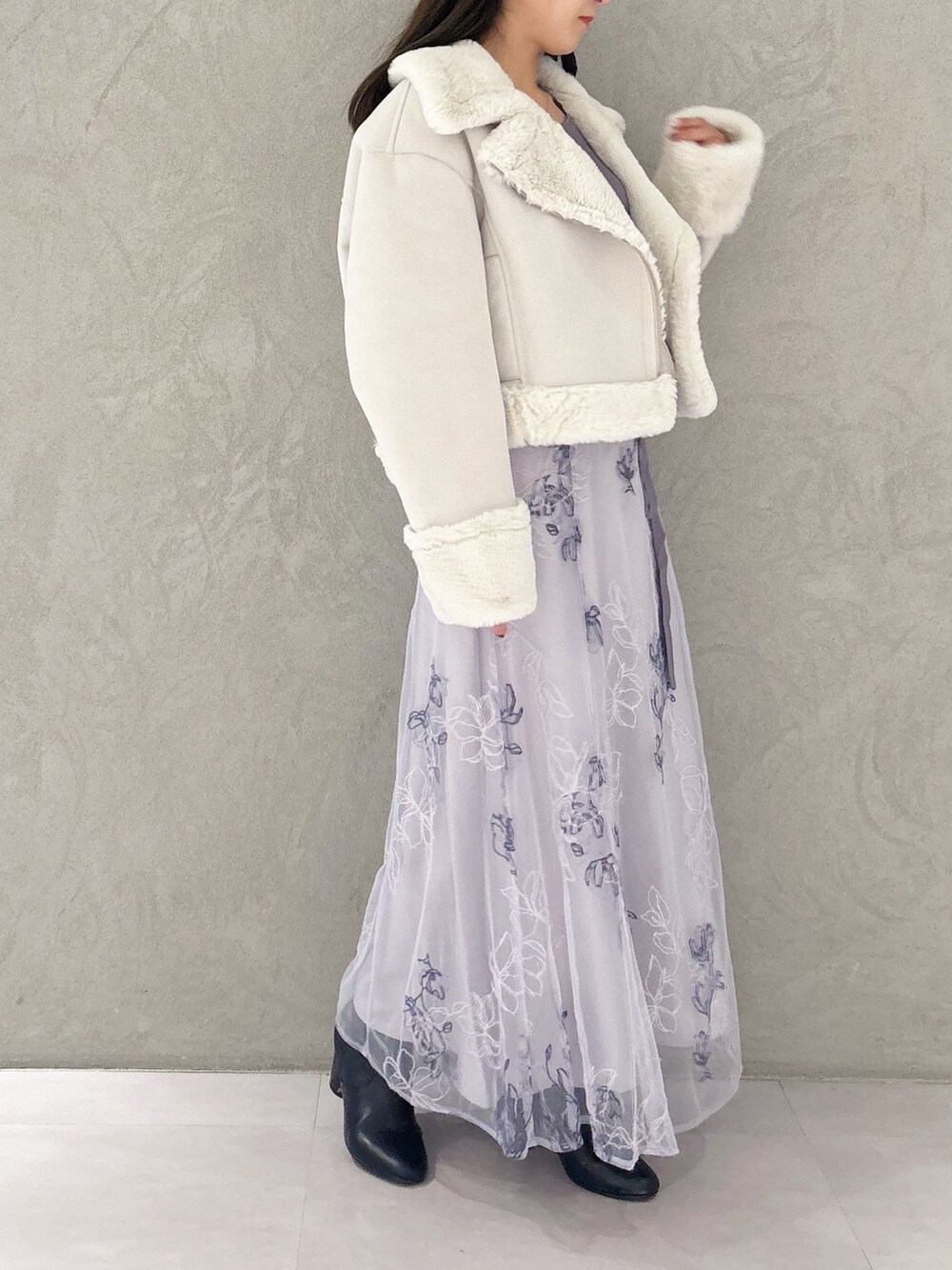 パープル系のワンピース、ブラック系のブーツ、グレー系のムートンコートを着用したレディースの秋コーディネートの6枚目の写真