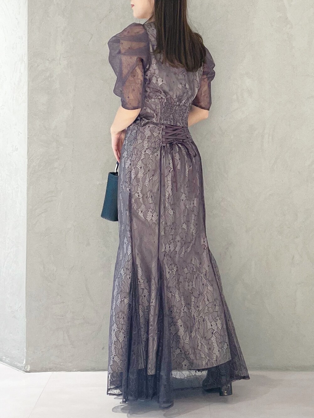 パープル系のシャツ/ブラウス、ブラック系のハンドバッグ、ブラック系のブーツを着用したレディースの冬コーディネートの4枚目の写真