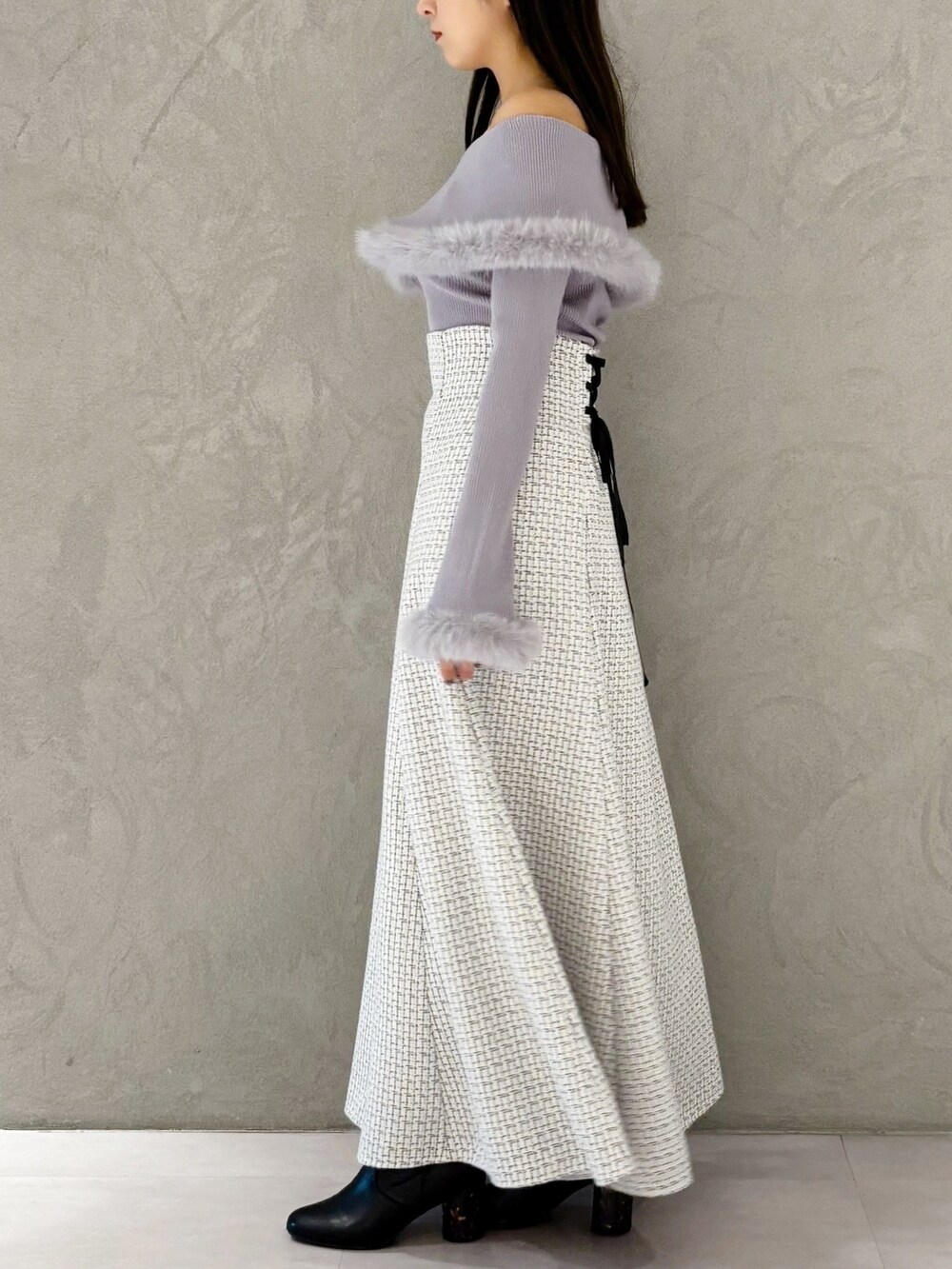 ホワイト系のスカート、ブラック系のブーツ、ホワイト系のショルダーバッグを着用したレディースの冬コーディネートの6枚目の写真