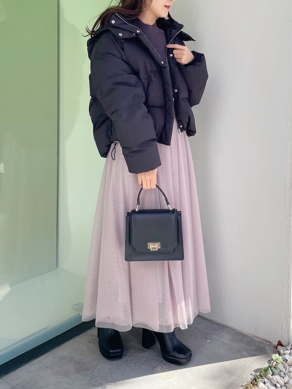 グレー系のワンピース、ブラック系のダウンジャケット/コート、ブラック系のハンドバッグを着用したレディースの冬コーディネートの5枚目の写真