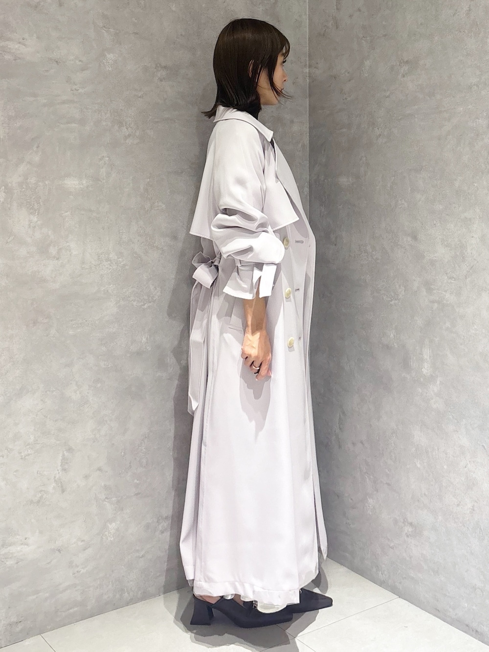 ブラック系のワンピース、ブラウン系のパンプス、パープル系のトレンチコートを着用したレディースの春コーディネートの4枚目の写真