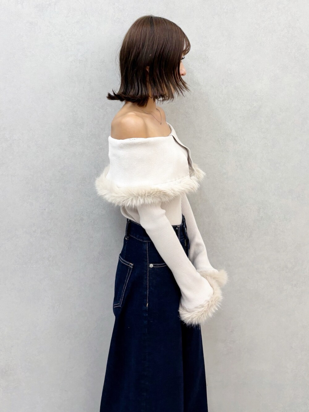 ブルー系のデニムパンツ、ブラウン系のブーツ、ベージュ系のニット/セーターを着用したレディースの秋コーディネートの5枚目の写真
