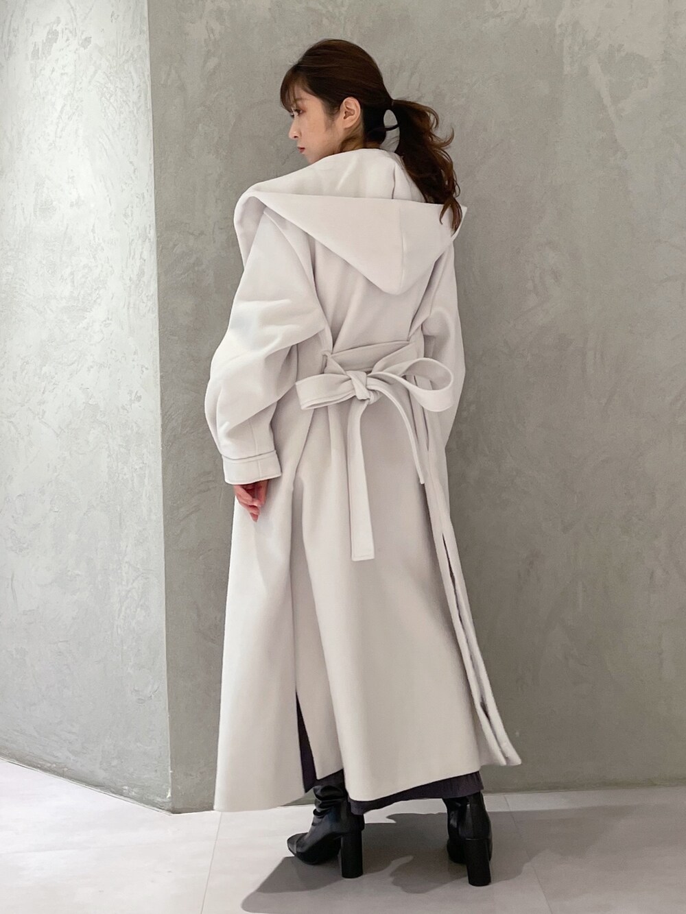 ホワイト系のチェスターコート、ブラック系のブーツ、ブルー系のワンピースを着用したレディースの秋コーディネートの5枚目の写真