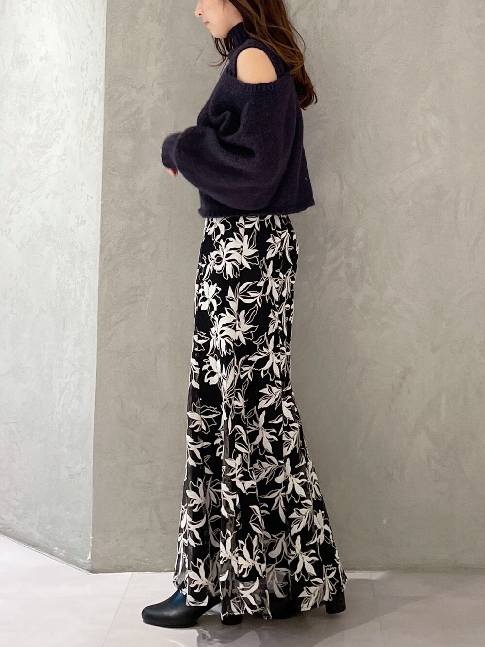 ブルー系のスカート、グレー系のニット/セーターを着用したレディースの秋コーディネートの6枚目の写真