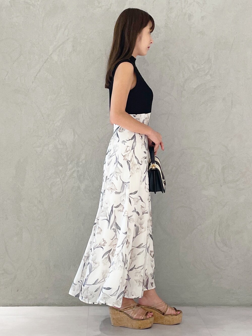 ブラック系のワンピース、ブラウン系のサンダル、ブラック系のハンドバッグを着用したレディースの夏コーディネートの5枚目の写真