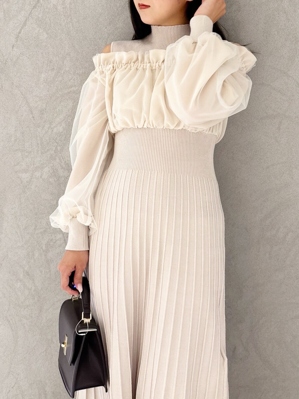 ホワイト系のワンピース、ブラウン系のブーツ、ブラウン系のハンドバッグを着用したレディースの冬コーディネートの8枚目の写真