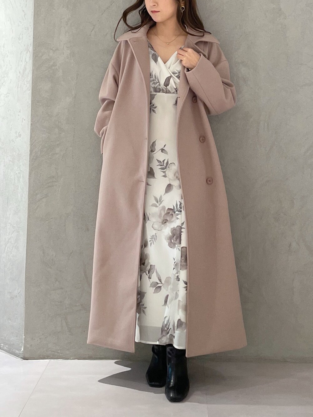 ホワイト系のワンピース、ベージュ系のステンカラーコート、ブラック系のブーツを着用したレディースの冬コーディネートの6枚目の写真