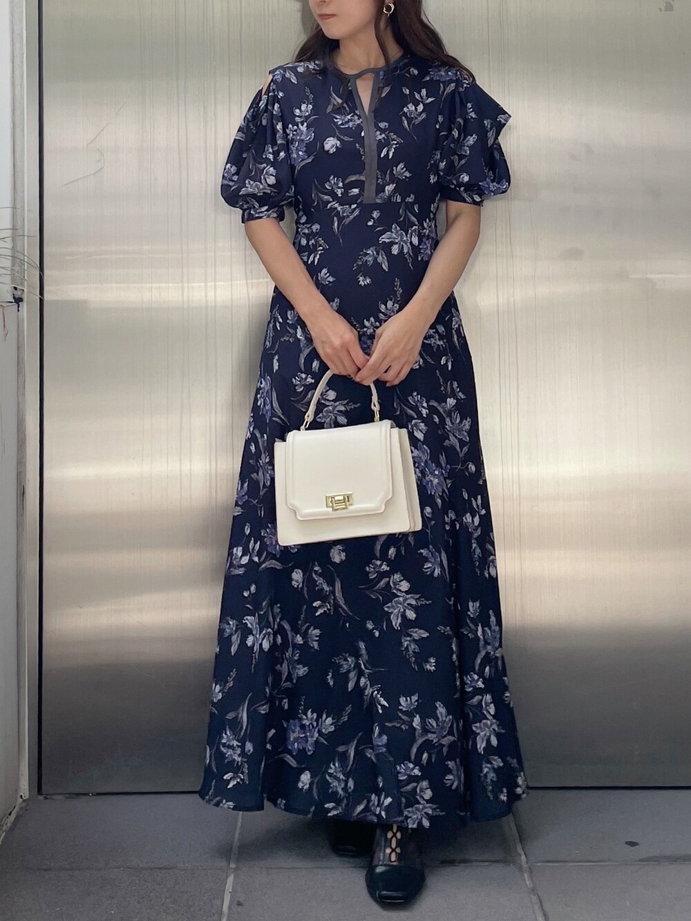 ホワイト系のハンドバッグ、ブルー系のワンピース、ブラック系のブーツを着用したレディースの夏コーディネートの3枚目の写真