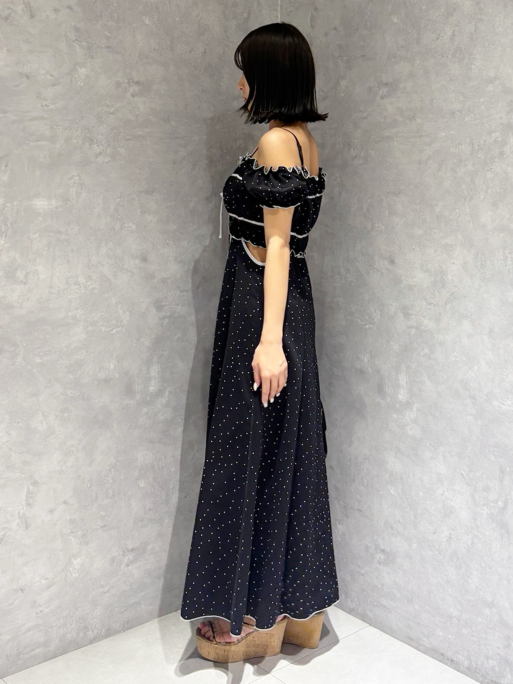 ブラック系のワンピース、ブラウン系のサンダル、ブラック系のショルダーバッグを着用したレディースの春コーディネートの4枚目の写真