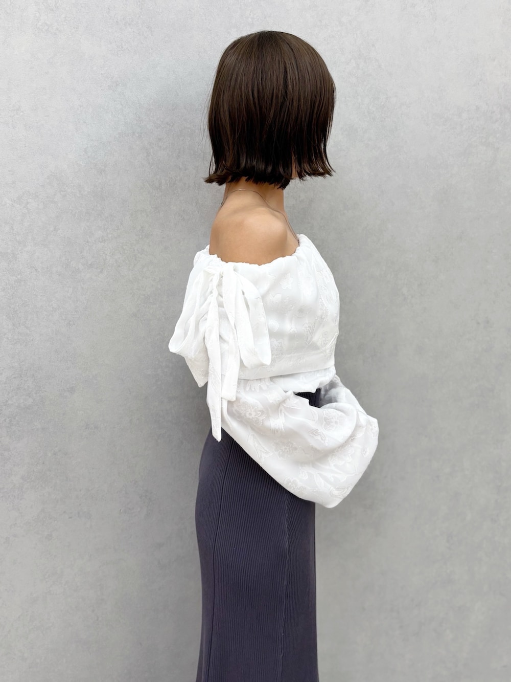 ブラウン系のパンプス、グレー系のワンピースを着用したレディースの冬コーディネートの3枚目の写真