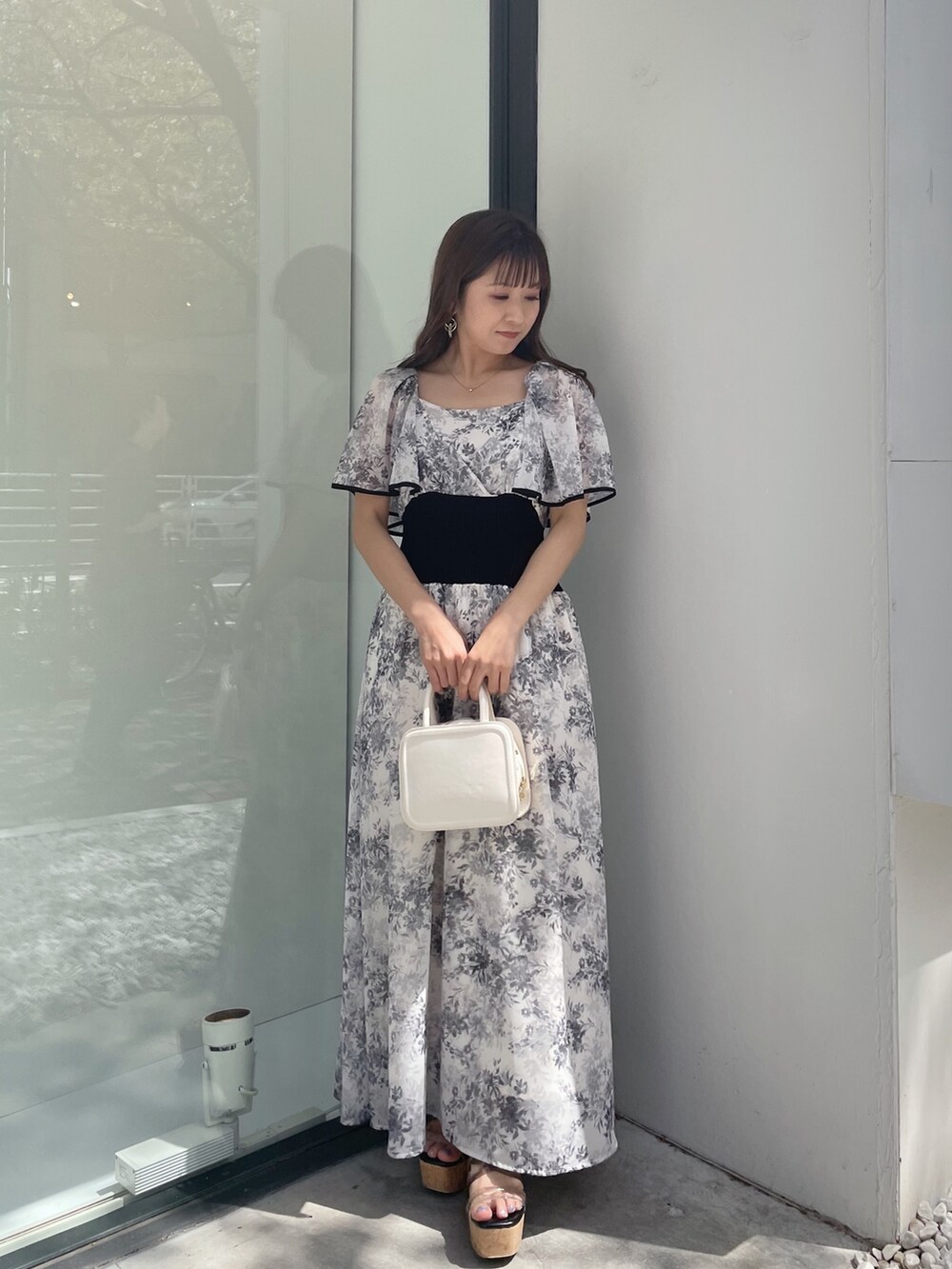 ブラック系のサンダル、ホワイト系のハンドバッグ、ホワイト系のワンピースを着用したレディースの春コーディネートの10枚目の写真