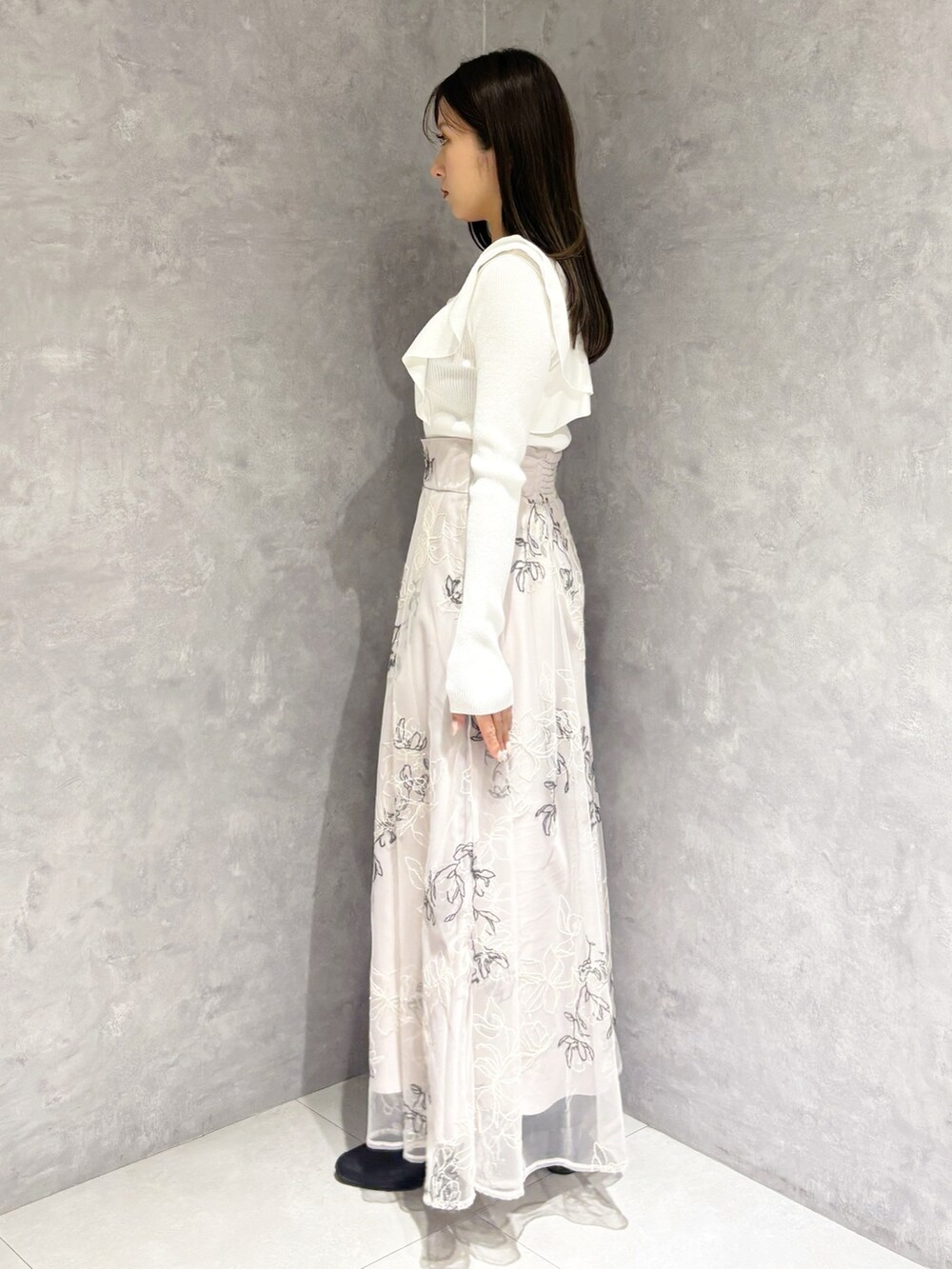 ブラウン系のハンドバッグ、ブラック系のブーツ、ベージュ系のスカートを着用したレディースの冬コーディネートの5枚目の写真