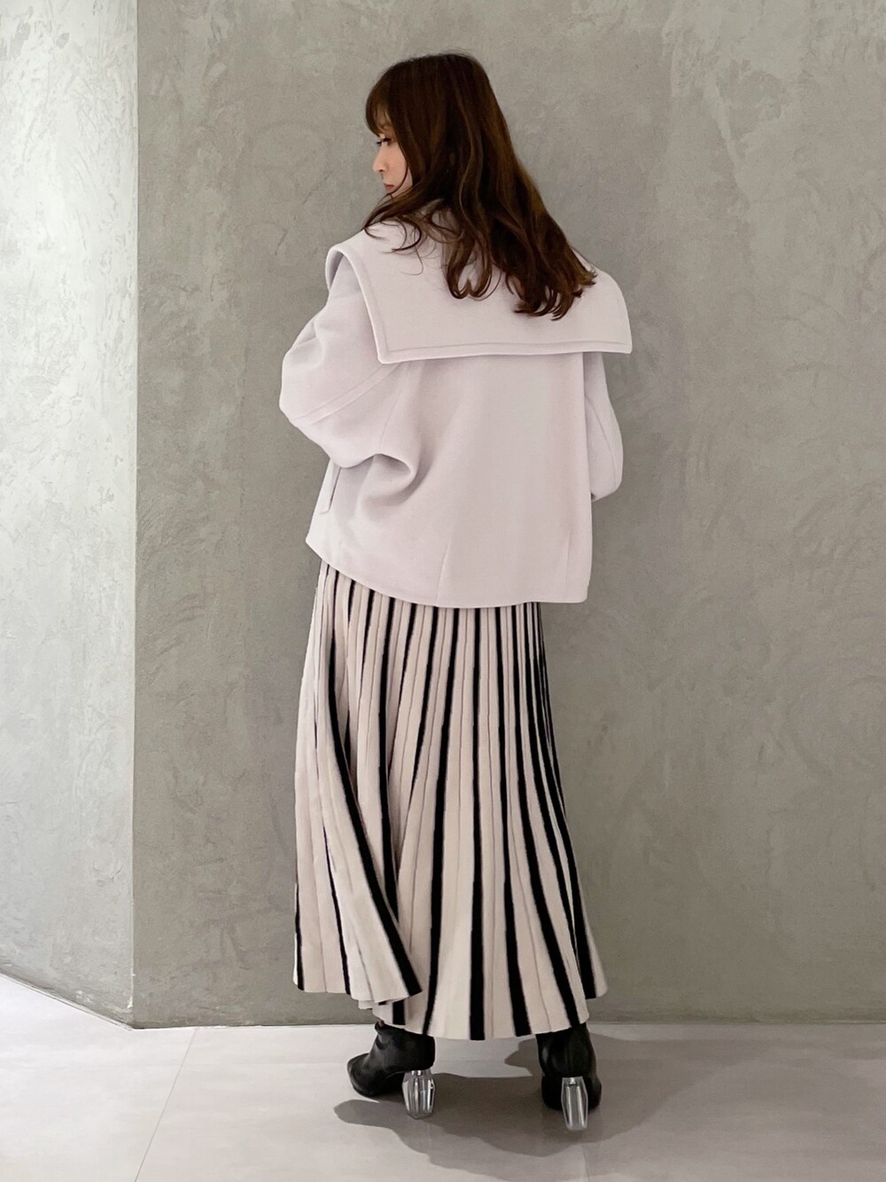 ブラック系のワンピース、グレー系のその他アウター、ブラック系のブーツを着用したレディースの冬コーディネートの3枚目の写真