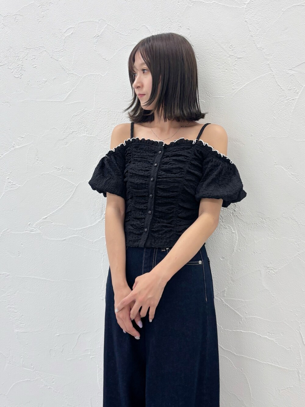 ブルー系のデニムパンツ、ホワイト系のサンダル、ブラック系のTシャツ/カットソーを着用したレディースの夏コーディネートの3枚目の写真