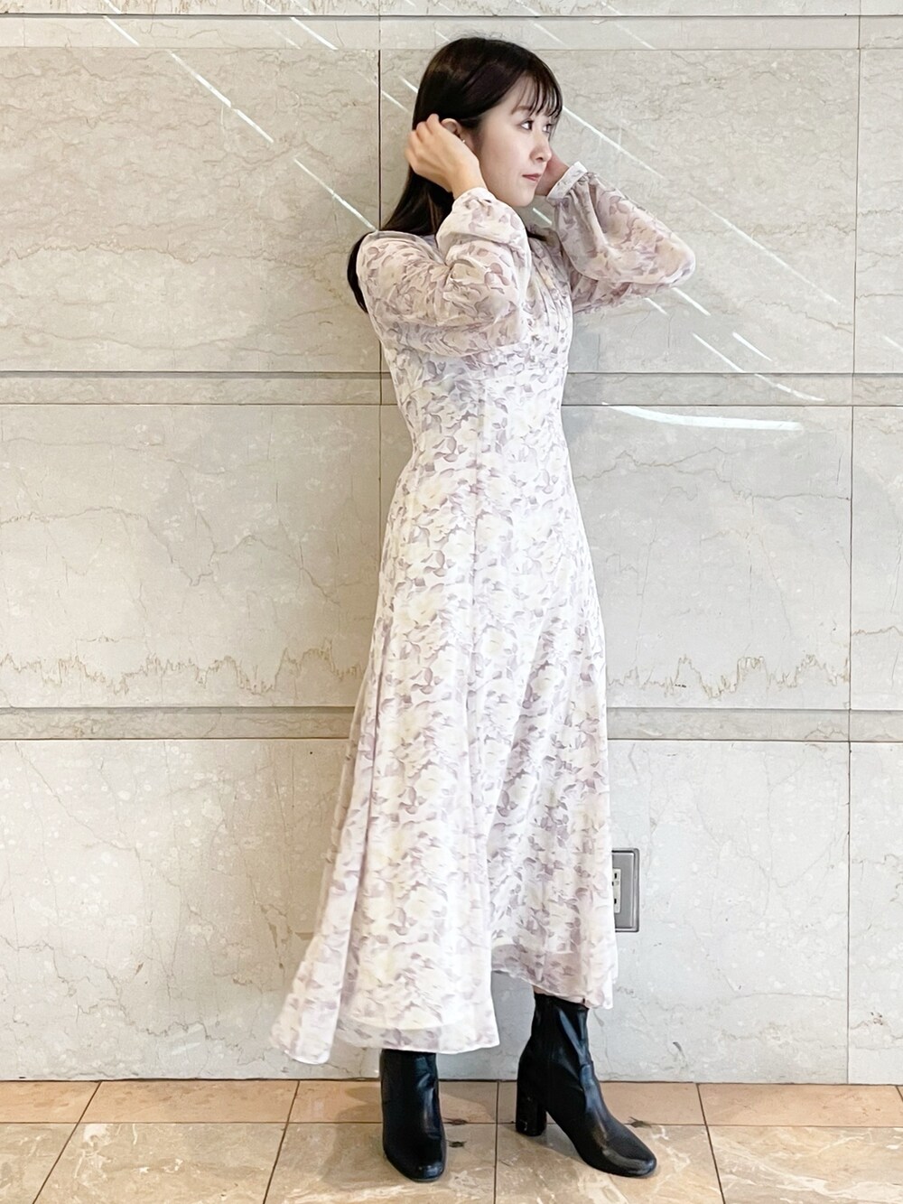 パープル系のワンピース、ブラック系のブーツを着用したレディースの冬コーディネートの2枚目の写真