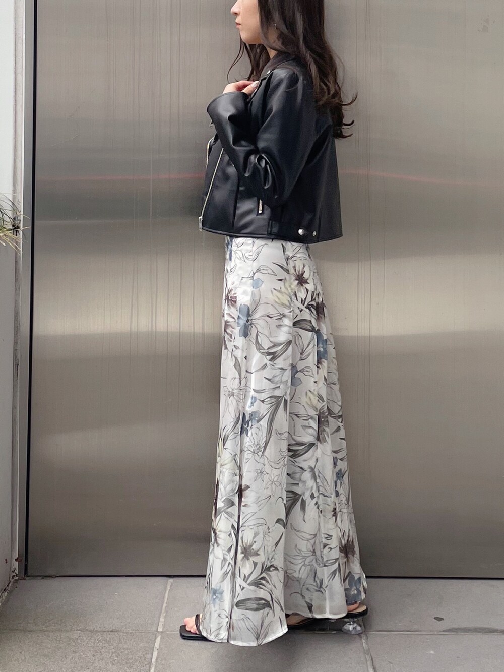 グリーン系のスカート、ブラック系のライダースジャケット、ブラック系のニット/セーターを着用したレディースの冬コーディネートの5枚目の写真