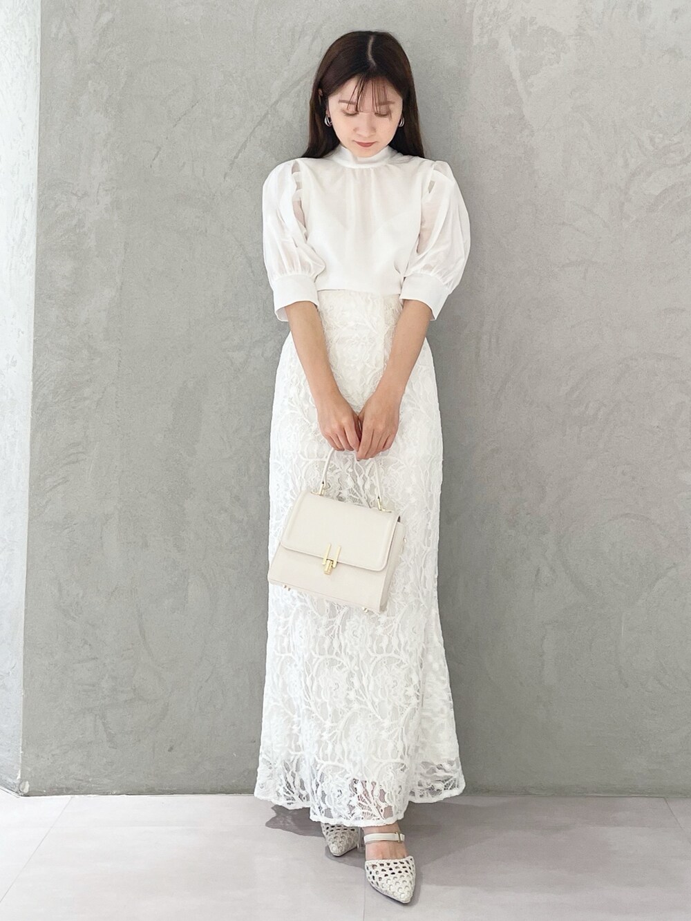 ホワイト系のスカート、ホワイト系のショルダーバッグ、ホワイト系のパンプスを着用したレディースの春コーディネートの5枚目の写真