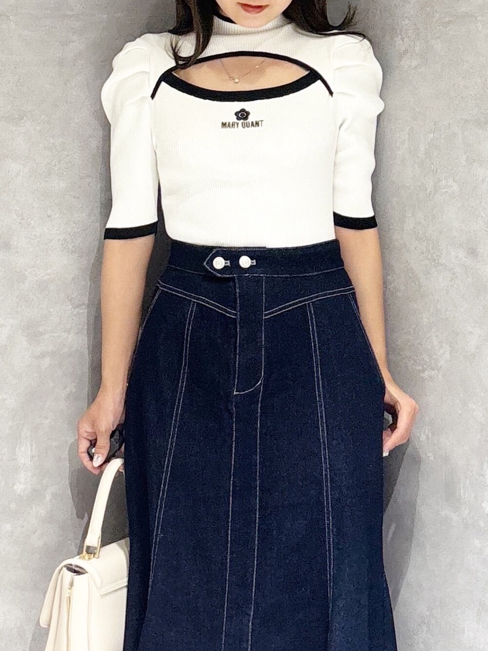 ブルー系のスカート、ホワイト系のパンプス、ホワイト系のハンドバッグを着用したレディースの春コーディネートの8枚目の写真