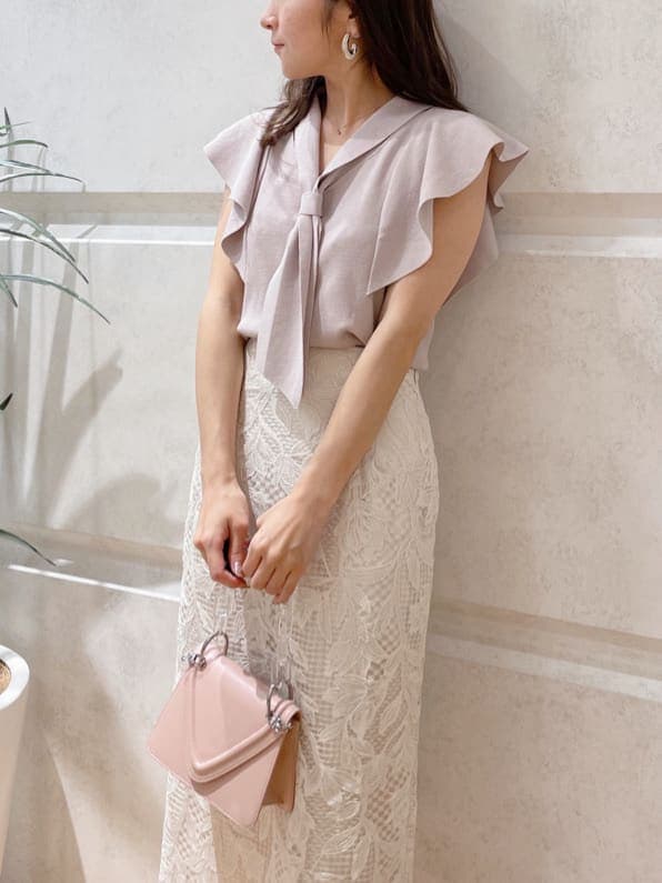 ホワイト系のスカート、ピンク系のショルダーバッグ、グリーン系のサンダルを着用したレディースの春コーディネートの2枚目の写真