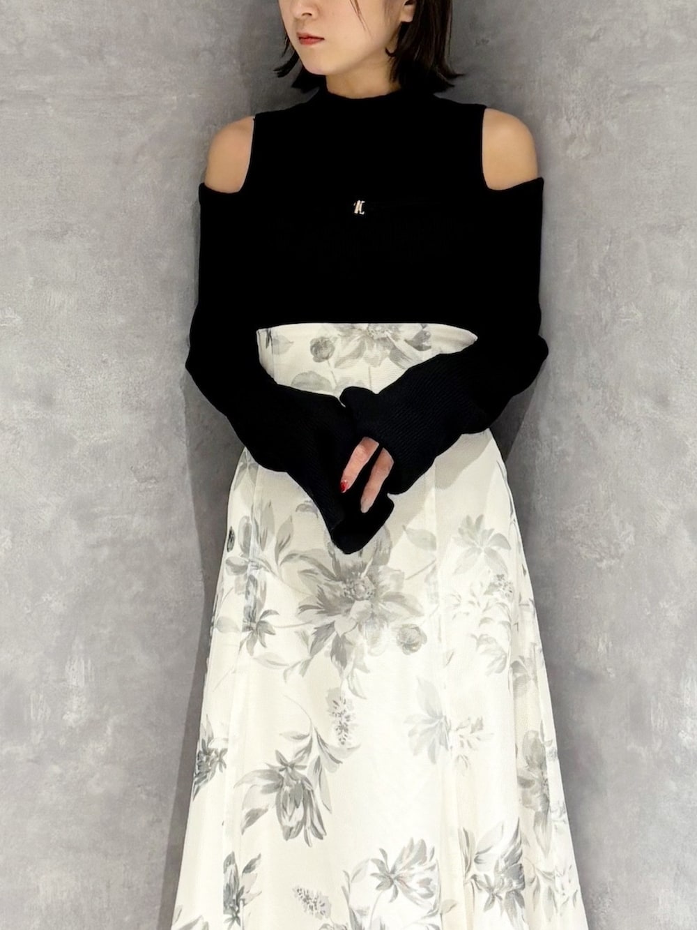 ホワイト系のスカート、ブラック系のニット/セーター、ブラック系のブーツを着用したレディースの冬コーディネートの6枚目の写真