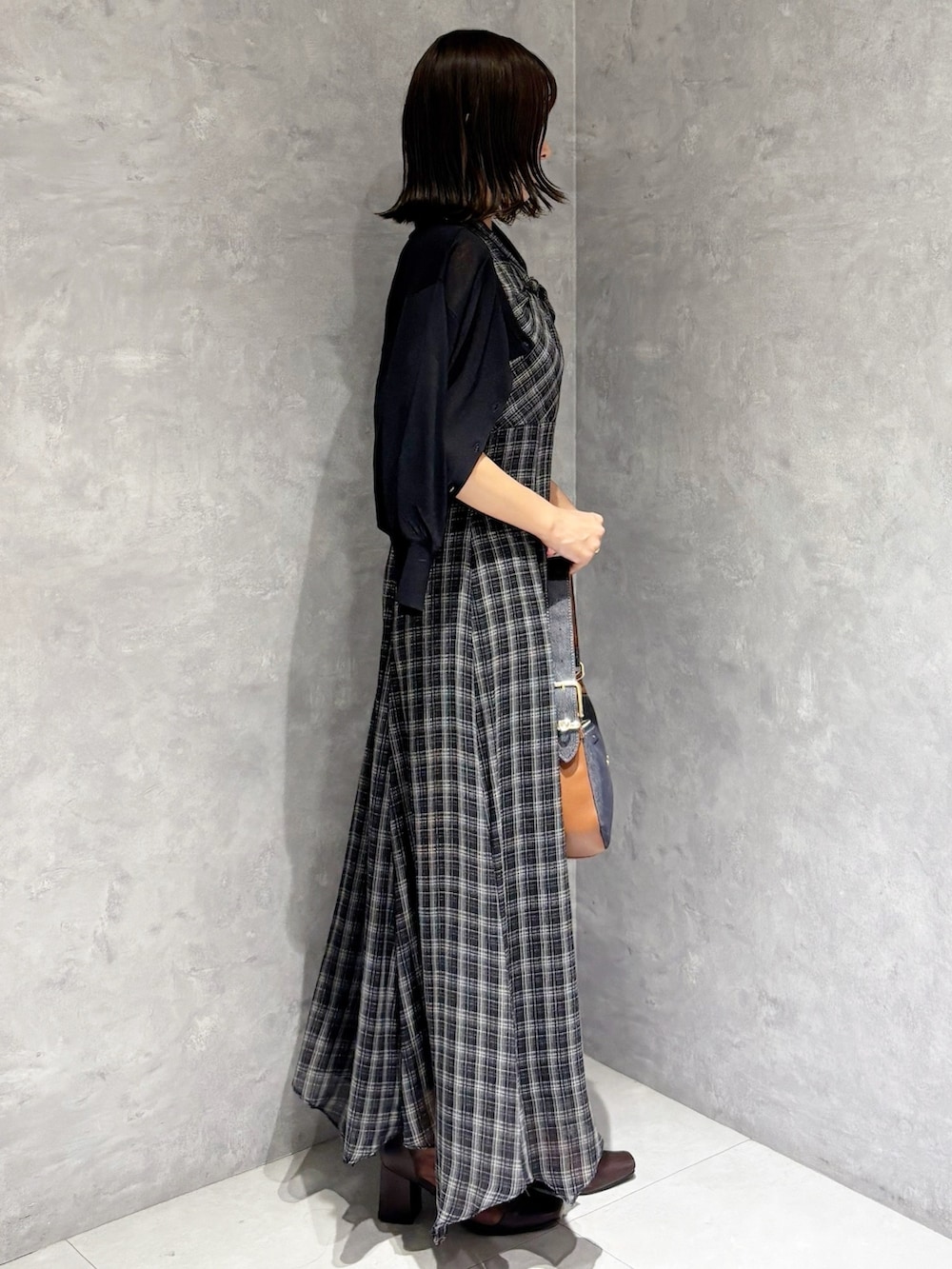 ブラック系のワンピース、ブラウン系のブーツ、ブラック系のカーディガン/ボレロを着用したレディースの夏コーディネートの3枚目の写真