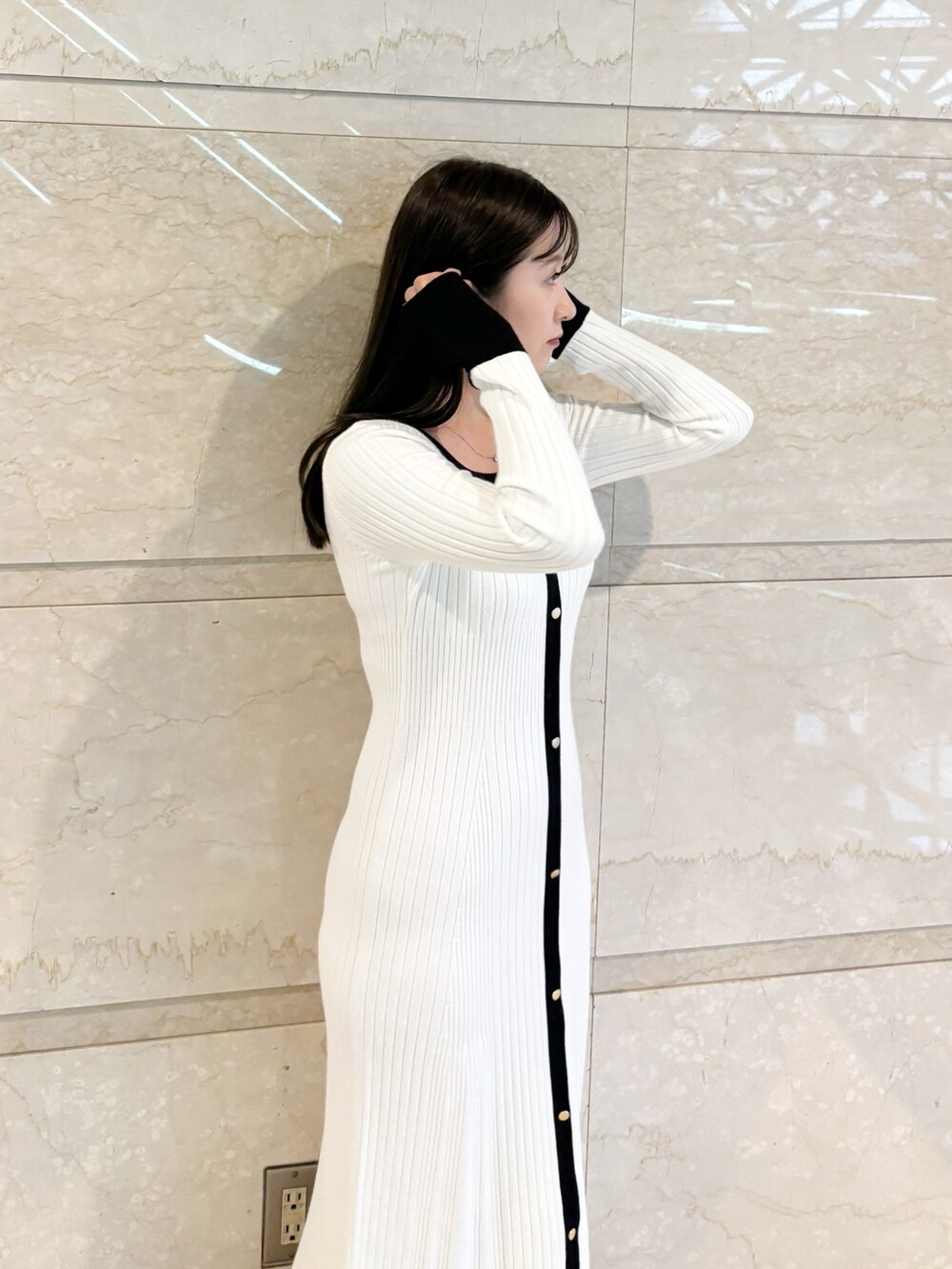 ホワイト系のワンピース、ブラック系のブーツを着用したレディースの冬コーディネートの5枚目の写真