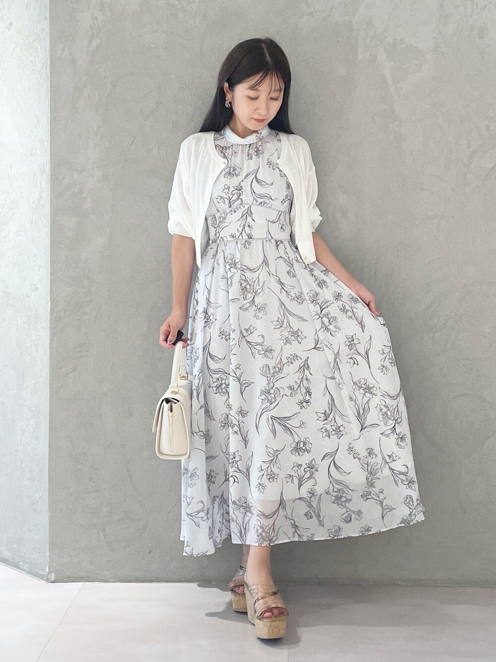 グレー系のワンピース、ブラウン系のサンダル、ホワイト系のショルダーバッグを着用したレディースの夏コーディネートの5枚目の写真