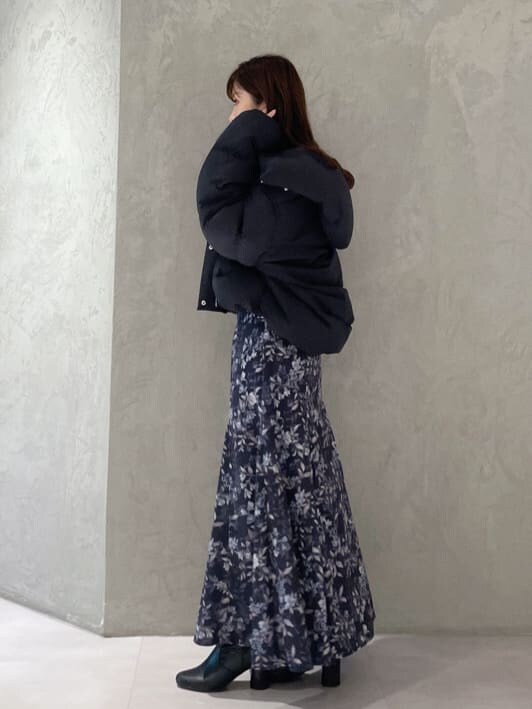 ブラック系のダウンジャケット/コート、ブラック系のニット/セーター、ブルー系のスカートを着用したレディースの秋コーディネートの2枚目の写真