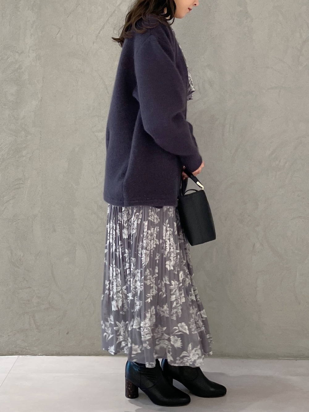 パープル系のワンピース、ブラック系のブーツ、ブラック系のハンドバッグを着用したレディースの秋コーディネートの5枚目の写真