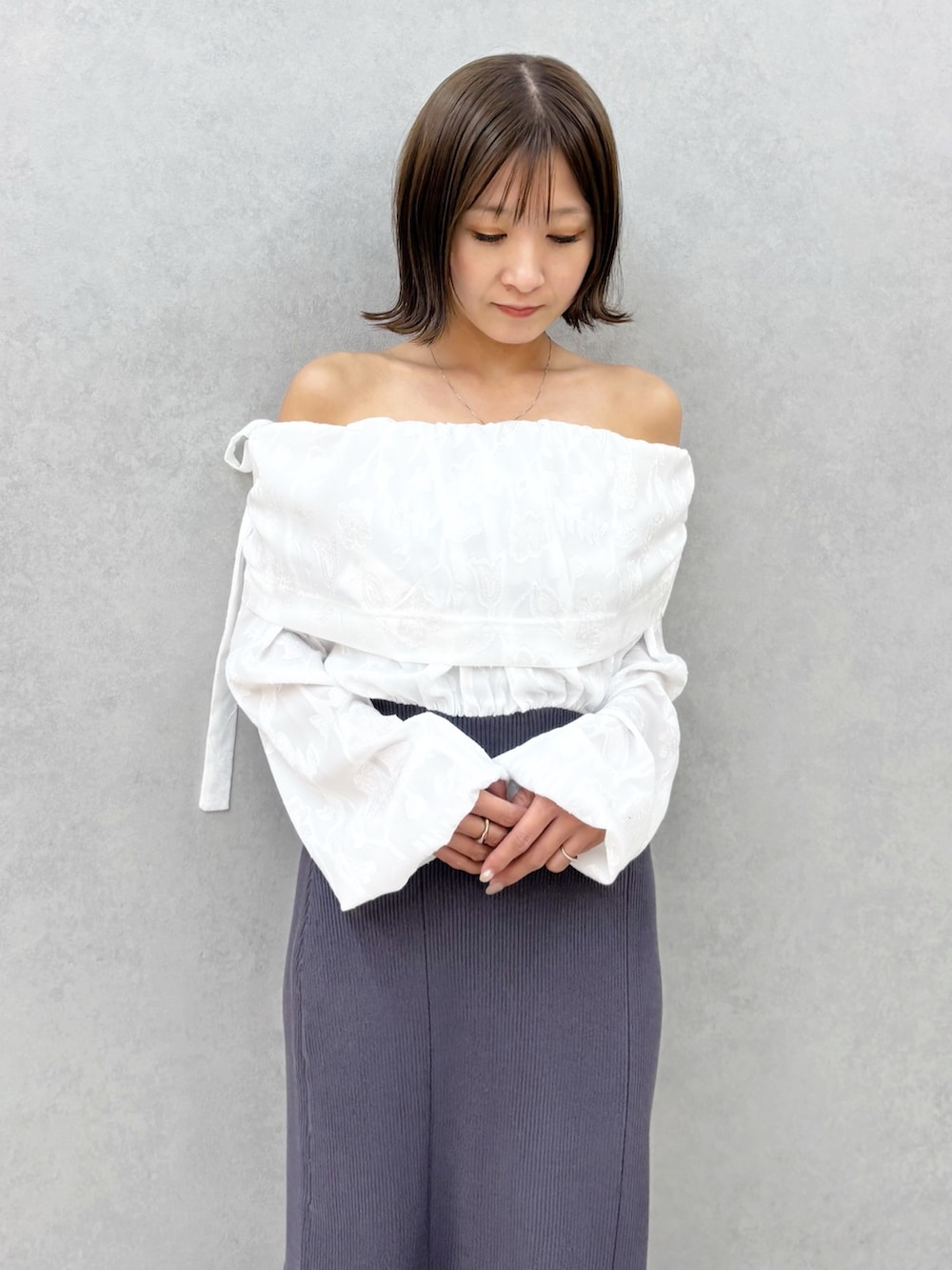 ブラウン系のパンプス、グレー系のワンピースを着用したレディースの冬コーディネートの2枚目の写真