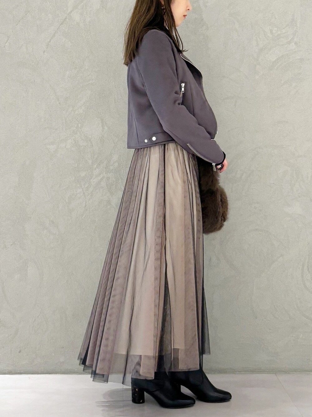 ブラック系のワンピース、ブラック系のブーツ、ブラウン系のハンドバッグを着用したレディースの秋コーディネートの2枚目の写真