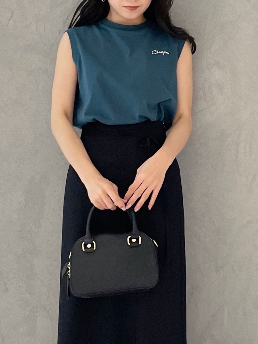 ブラック系のスカート、ブラック系のサンダル、ブラック系のボストンバッグを着用したレディースの春コーディネートの3枚目の写真