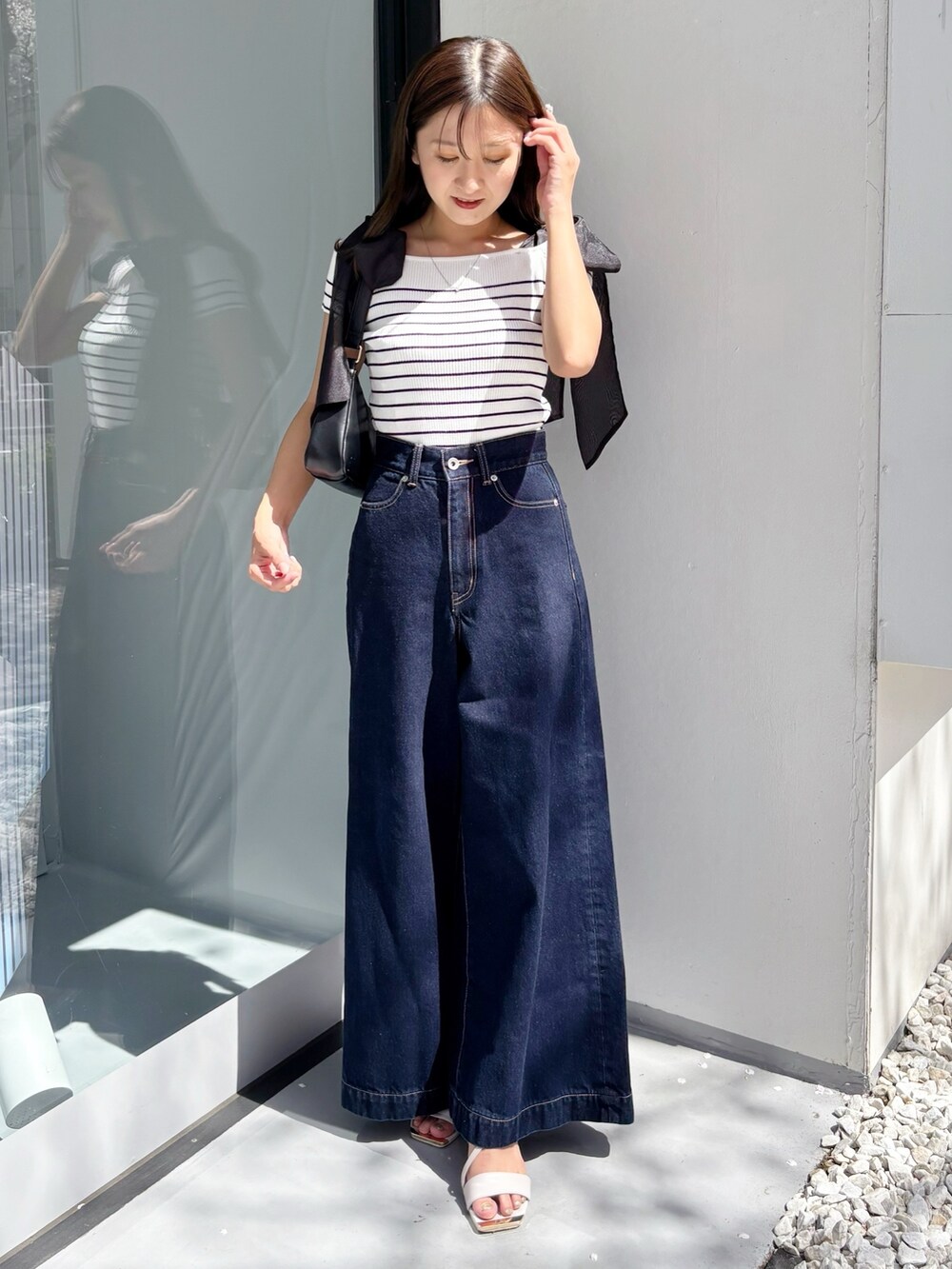 ブルー系のデニムパンツ、その他のニット/セーター、ホワイト系のサンダルを着用したレディースの夏コーディネートの8枚目の写真