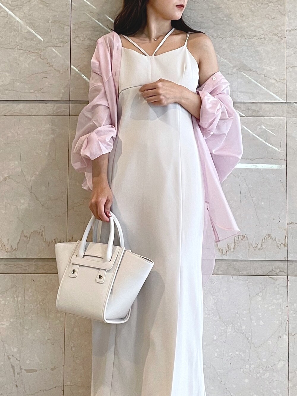 ホワイト系のトートバッグ、ブラック系のサンダル、ベージュ系のワンピースを着用したレディースの夏コーディネートの5枚目の写真