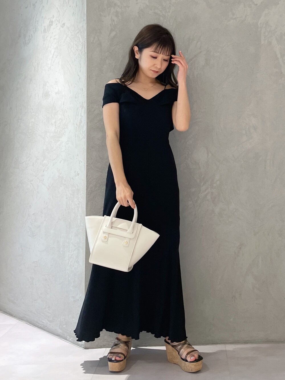 ホワイト系のトートバッグ、ブラック系のサンダル、ブラック系のワンピースを着用したレディースの夏コーディネートの4枚目の写真
