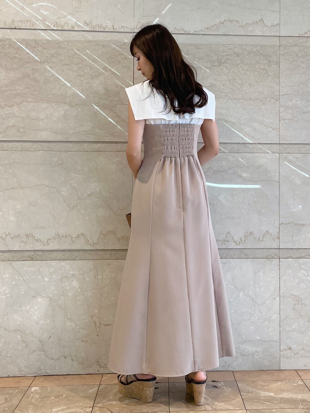 ベージュ系のワンピース、ブラック系のサンダル、ブラウン系のトートバッグを着用したレディースの夏コーディネートの3枚目の写真