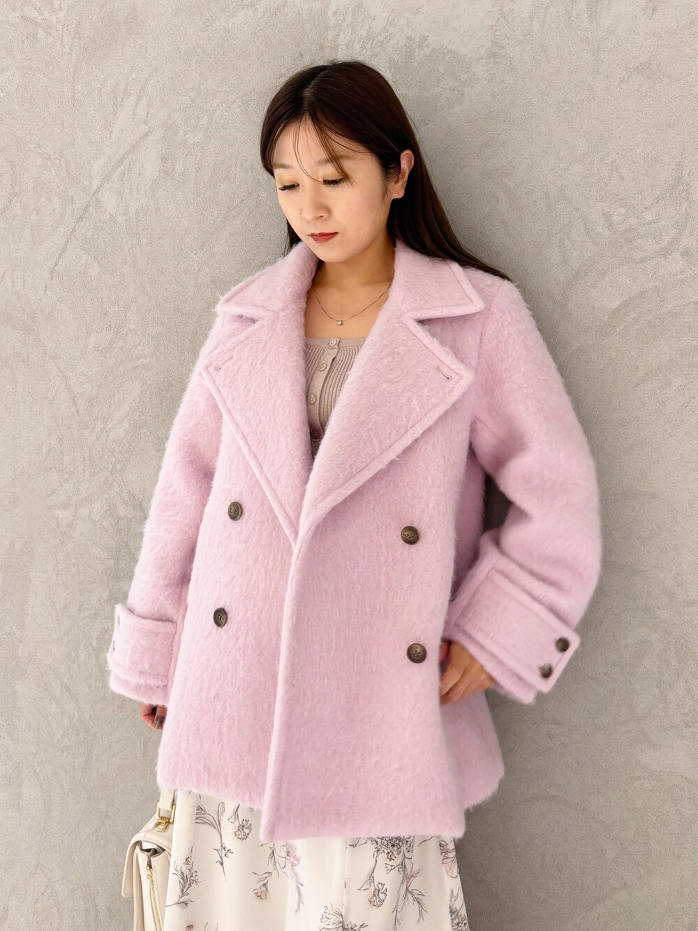 ベージュ系のワンピース、ブラック系のブーツ、ホワイト系のハンドバッグを着用したレディースの冬コーディネートの3枚目の写真