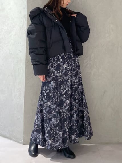 ブラック系のダウンジャケット/コート、ブラック系のニット/セーター、ブルー系のスカートを着用したレディースの秋コーディネートの3枚目の写真