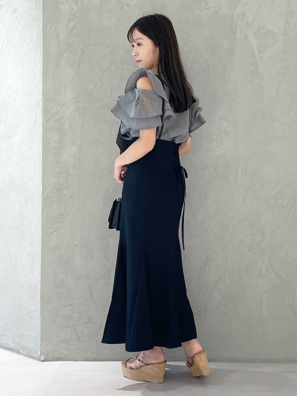 ブラック系のスカート、ブラウン系のサンダル、ブラック系のショルダーバッグを着用したレディースの夏コーディネートの4枚目の写真