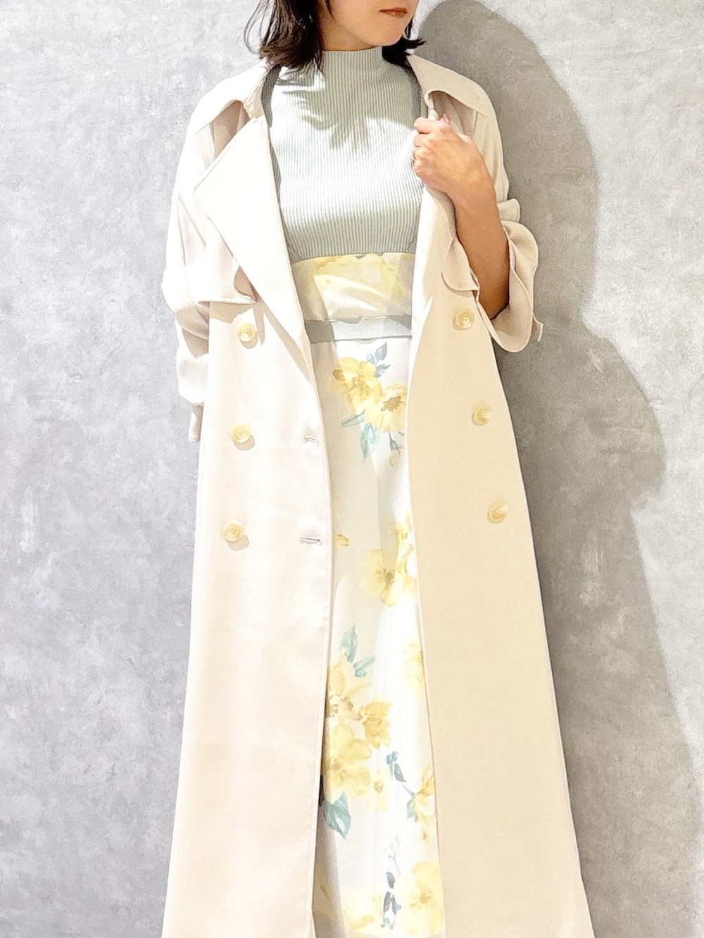 グリーン系のワンピース、ホワイト系のトレンチコート、ブラウン系のパンプスを着用したレディースの春コーディネートの4枚目の写真