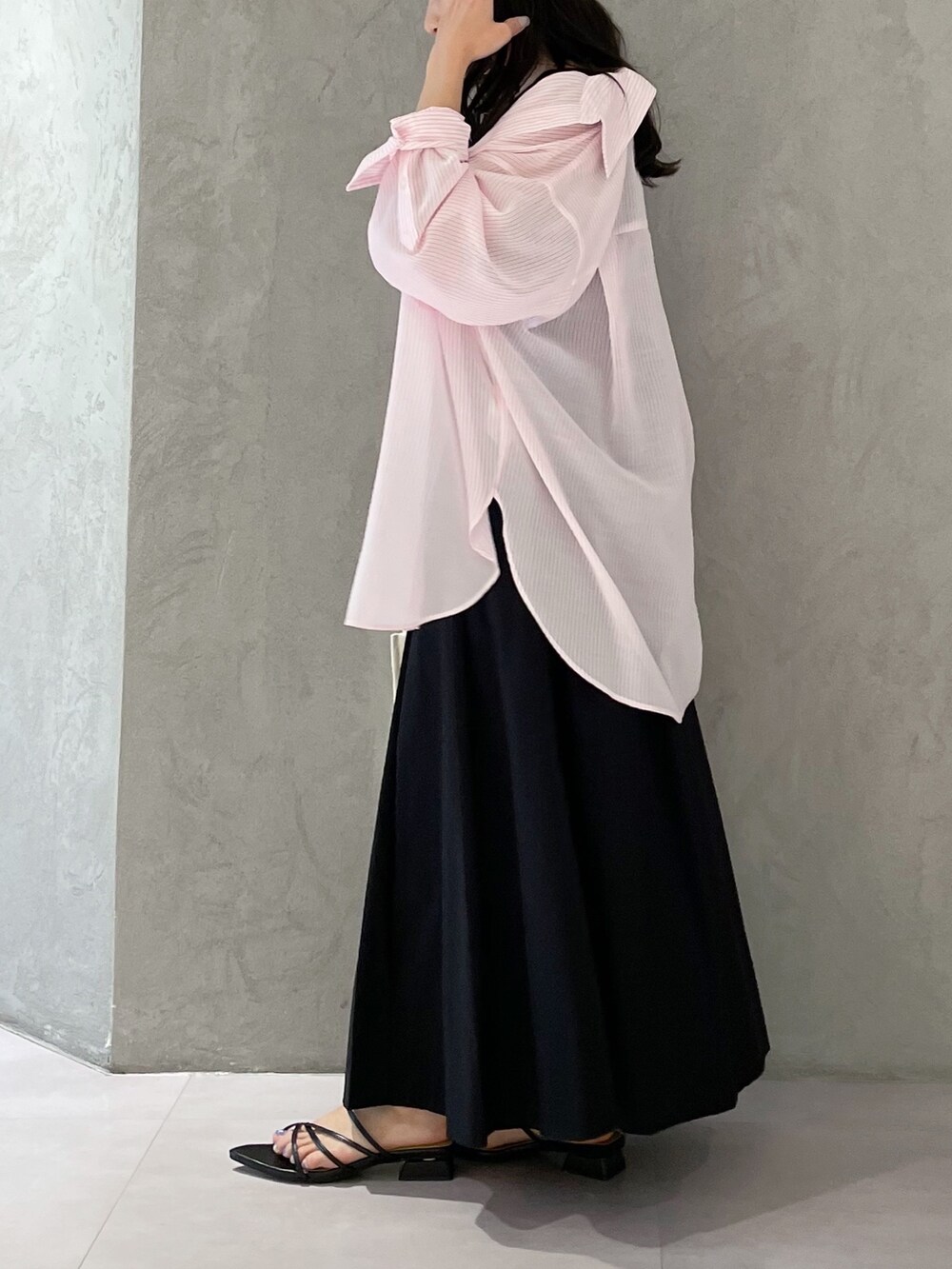 ブラック系のワンピース、ブラック系のサンダル、ホワイト系のハンドバッグを着用したレディースの春コーディネートの4枚目の写真