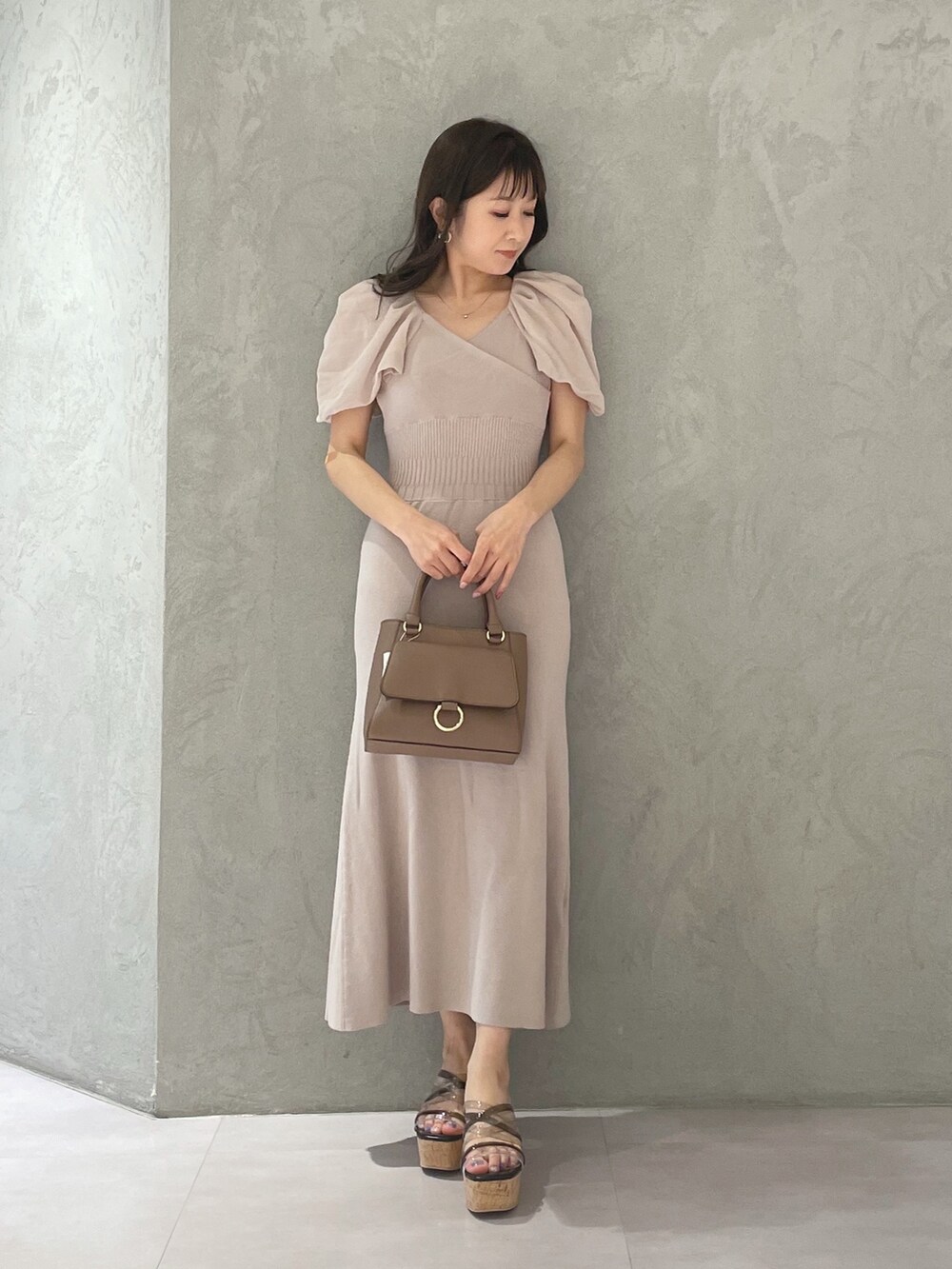 ブラック系のサンダル、ベージュ系のワンピースを着用したレディースの春コーディネートの3枚目の写真