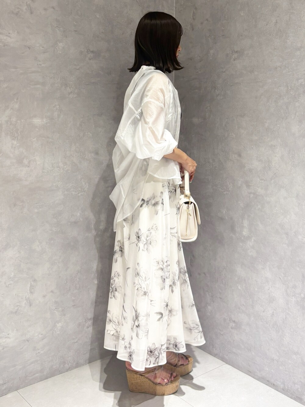 ホワイト系のワンピース、ブラウン系のサンダル、ホワイト系のハンドバッグを着用したレディースの夏コーディネートの4枚目の写真