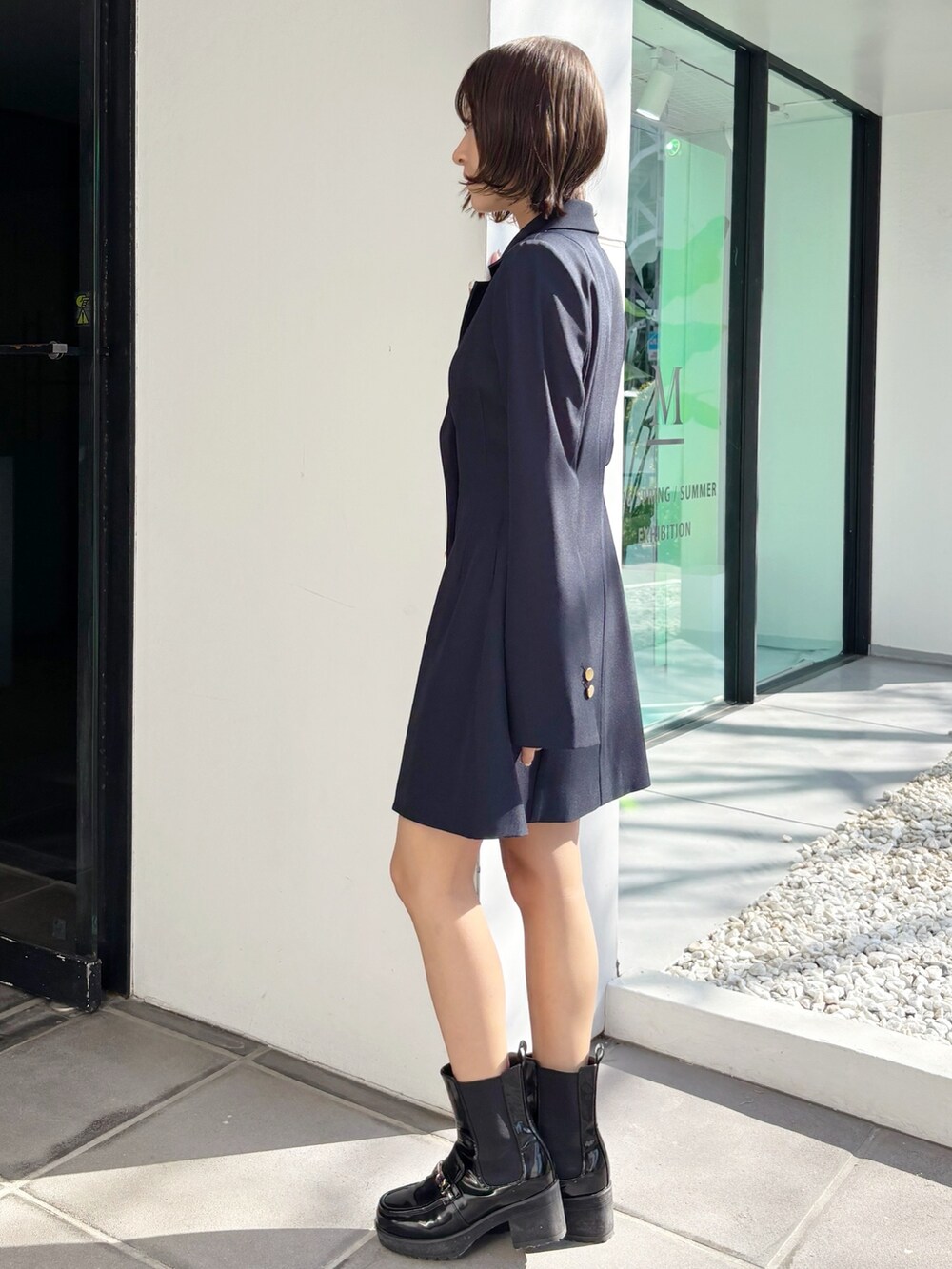 ブルー系のワンピース、ブラック系のブーツを着用したレディースの春コーディネートの3枚目の写真