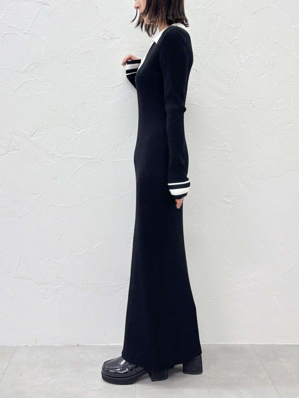 ブラック系のワンピース、ブラック系のブーツを着用したレディースの秋コーディネートの2枚目の写真