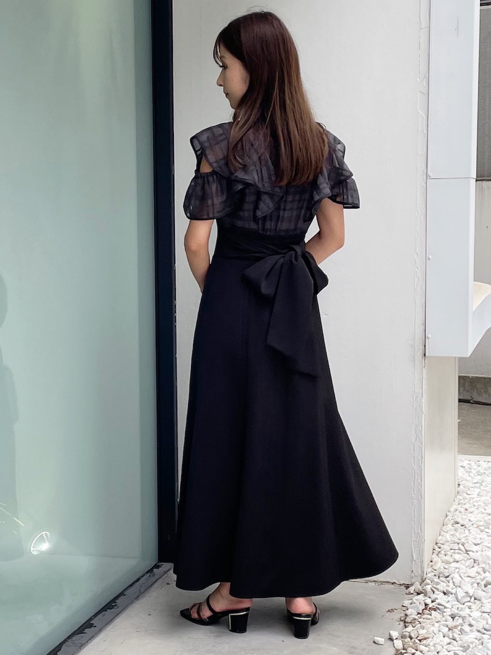 ブラック系のワンピース、ブラック系のサンダル、ホワイト系のショルダーバッグを着用したレディースの夏コーディネートの2枚目の写真