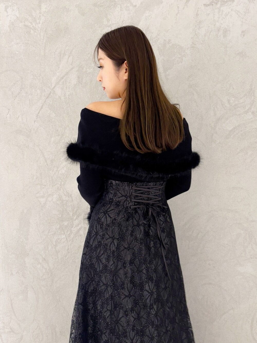 ブラック系のスカート、ブラック系のブーツ、ブラック系のショルダーバッグを着用したレディースの冬コーディネートの3枚目の写真