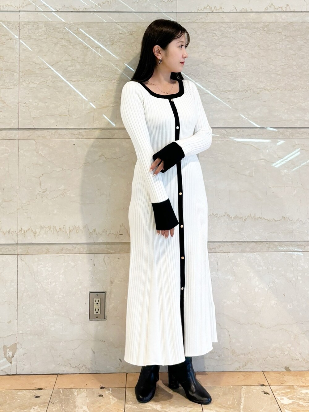 ホワイト系のワンピース、ブラック系のブーツを着用したレディースの冬コーディネートの8枚目の写真