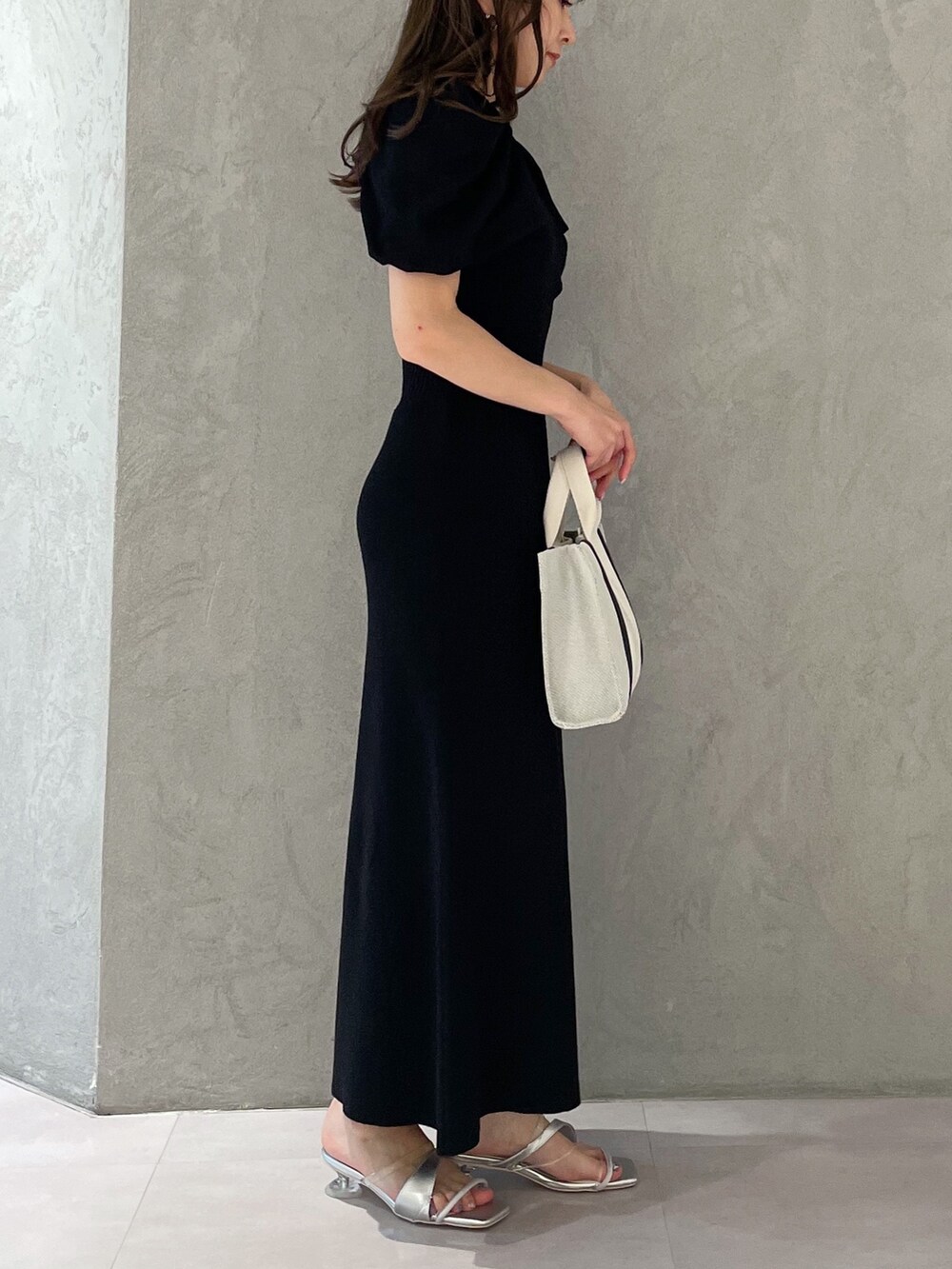 グレー系のワンピース、シルバー系のサンダル、グレー系のハンドバッグを着用したレディースの春コーディネートの4枚目の写真